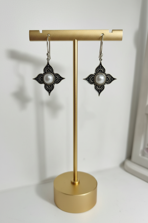 Aretes flor con perla del río en exhibidor